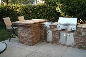 Nice stone outdoor kitchen kit with a built-in stainless steel grill.