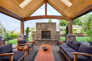 Outdoor stone fireplace in an outdoor living room with comfortable furniture