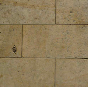 Earth tone limestone floor tile showing the porous nature of the stone