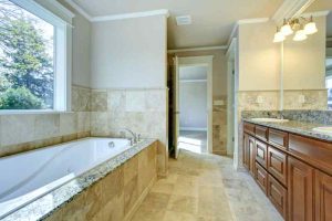 Beautiful master bathroom with natural stone tile and high end furnishings in luxury home.