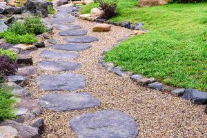 Image of a winding path of decorative landscape stone surrounded by bright green grass.