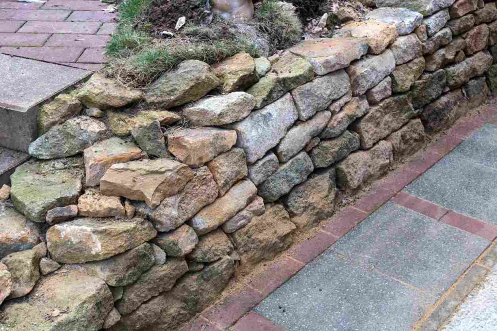 Natural retaining wall stones near a stone pathway.