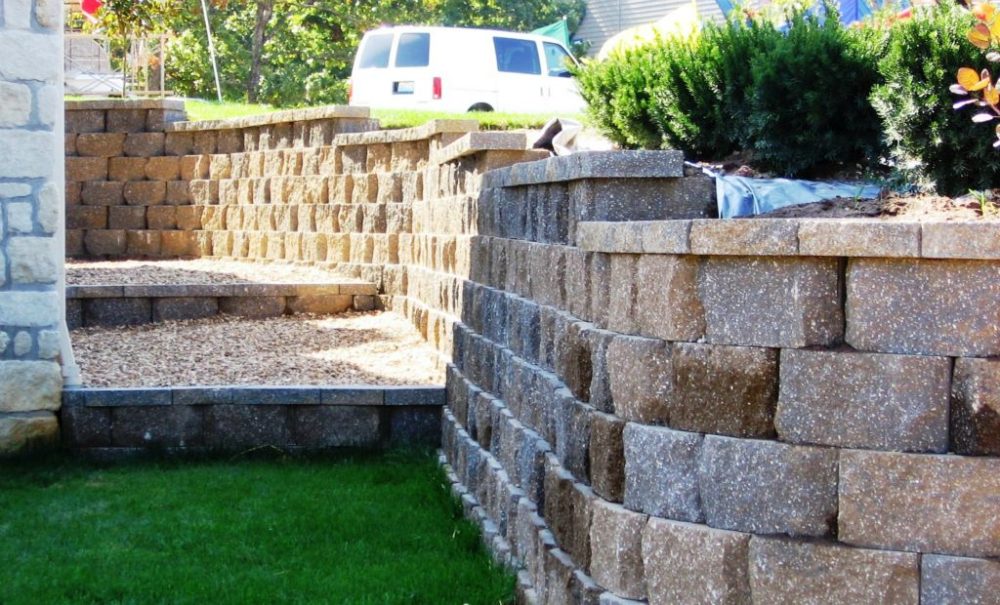 A multicolored retaining wall built with stone wall blocks from Southwest Stone Supply.