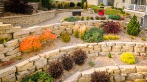 beautiful colorful landscape on three tiers with patio, stone walls, and short columns