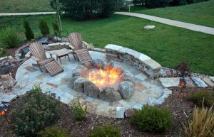 Fire pit built with boulders in oval shape and built-in seating