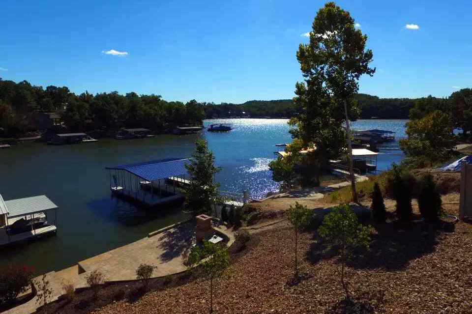 Low-maintenance lakeside Missouri landscape with gravel ground cover, stone patio, and established plantings that require almost no ongoing care after the first year of establishment.